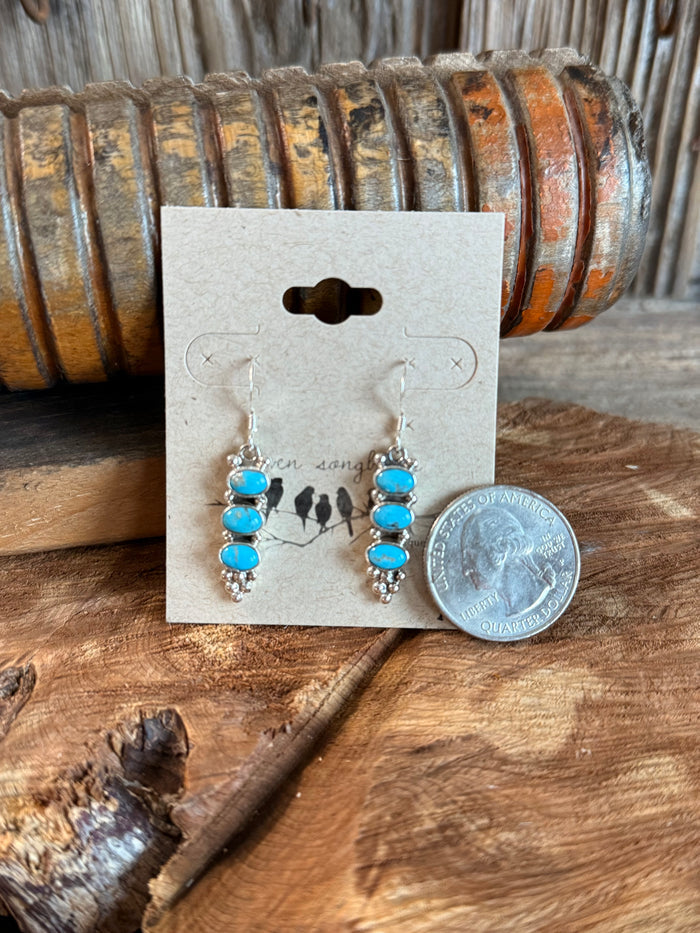 Turquoise triple-stacked cluster earrings with silver-tone hooks; side view, coin for scale