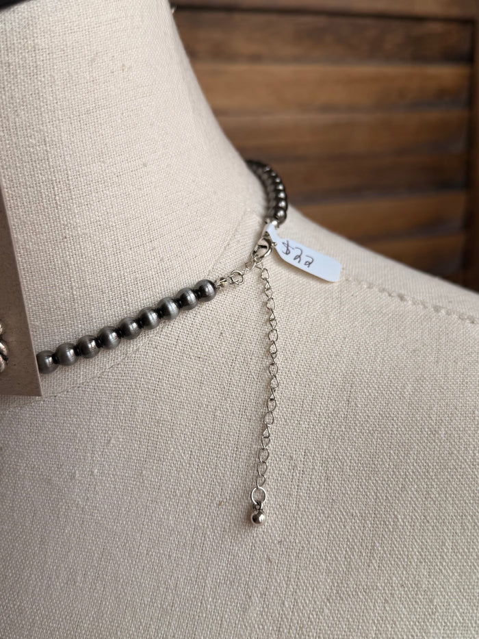 Turquoise snaffle bit charm necklace on a silver-tone rope chain