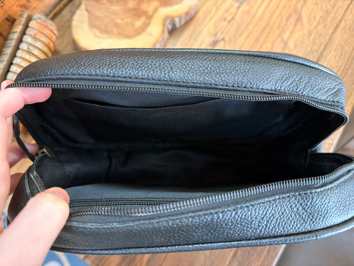 Inside view of dark blue crossbody purse: zip-top opening and main compartment lining