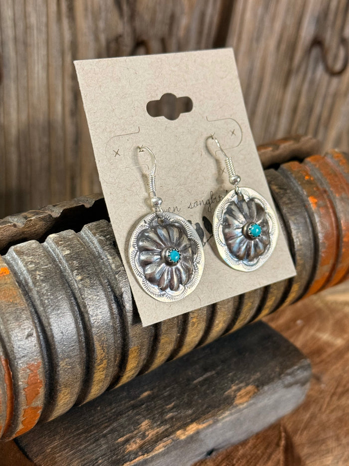 Turquoise concho fishhook earrings with ornate round silver frames and blue center stones