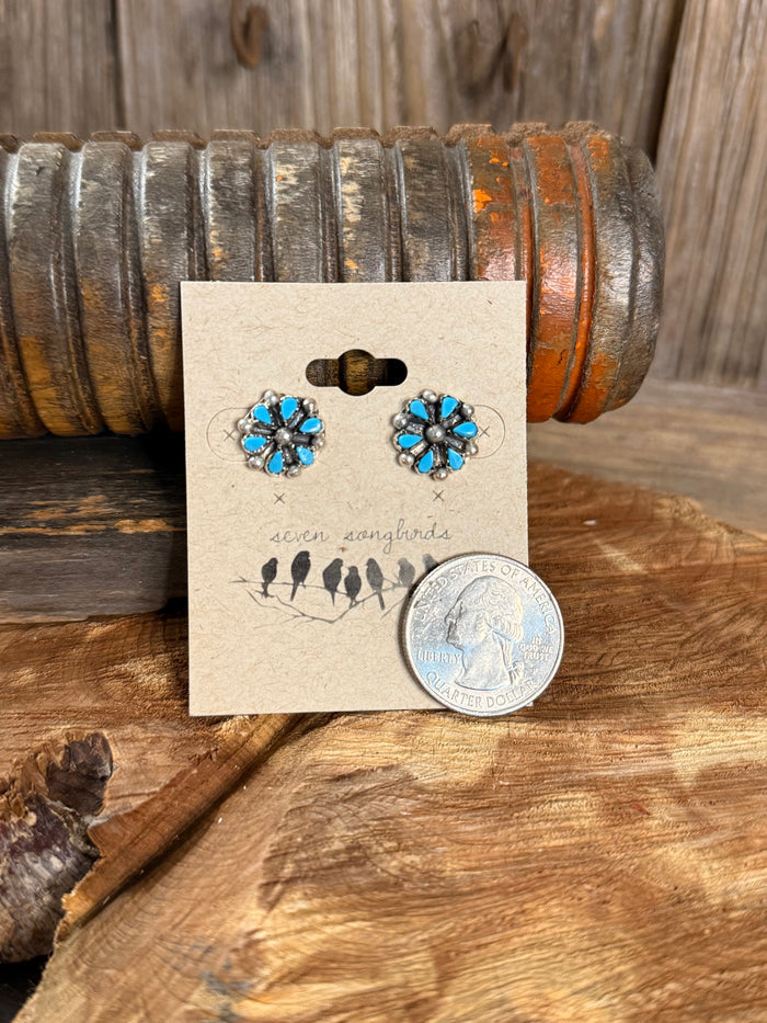 Turquoise blue flower stud earrings with coin for scale, silver-tone metal