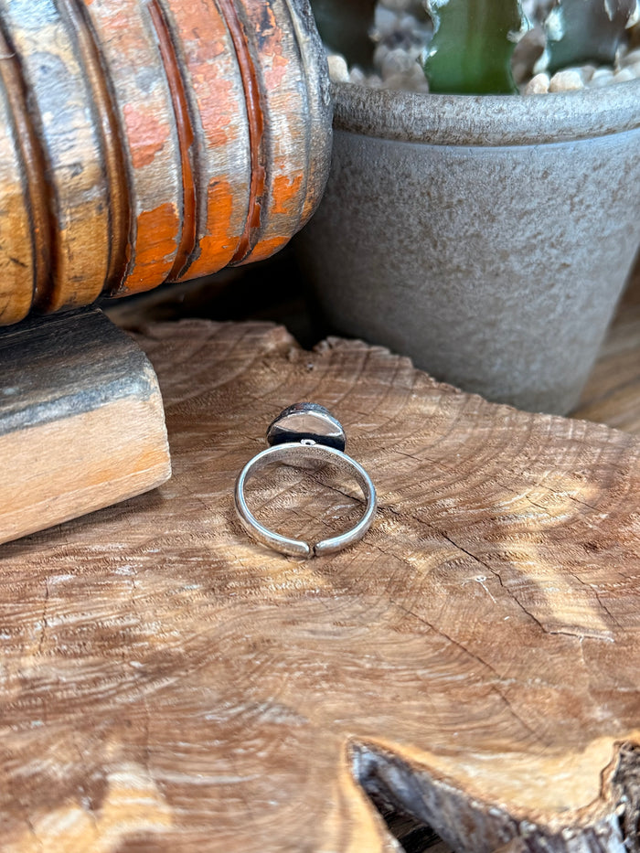 Silver-plated adjustable stone ring with blue centerpiece seen from side