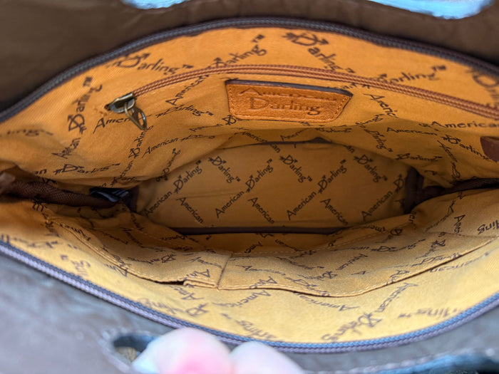 Crossbody purse interior lining with tan patterned fabric and zippered opening