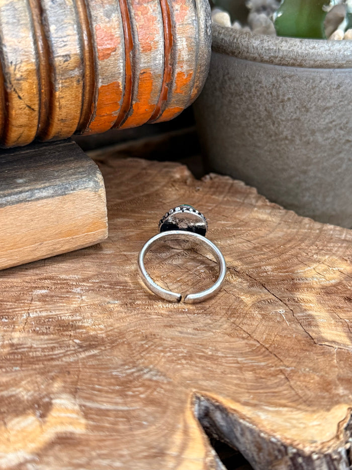 Adjustable silver-toned ring band, side view with open back