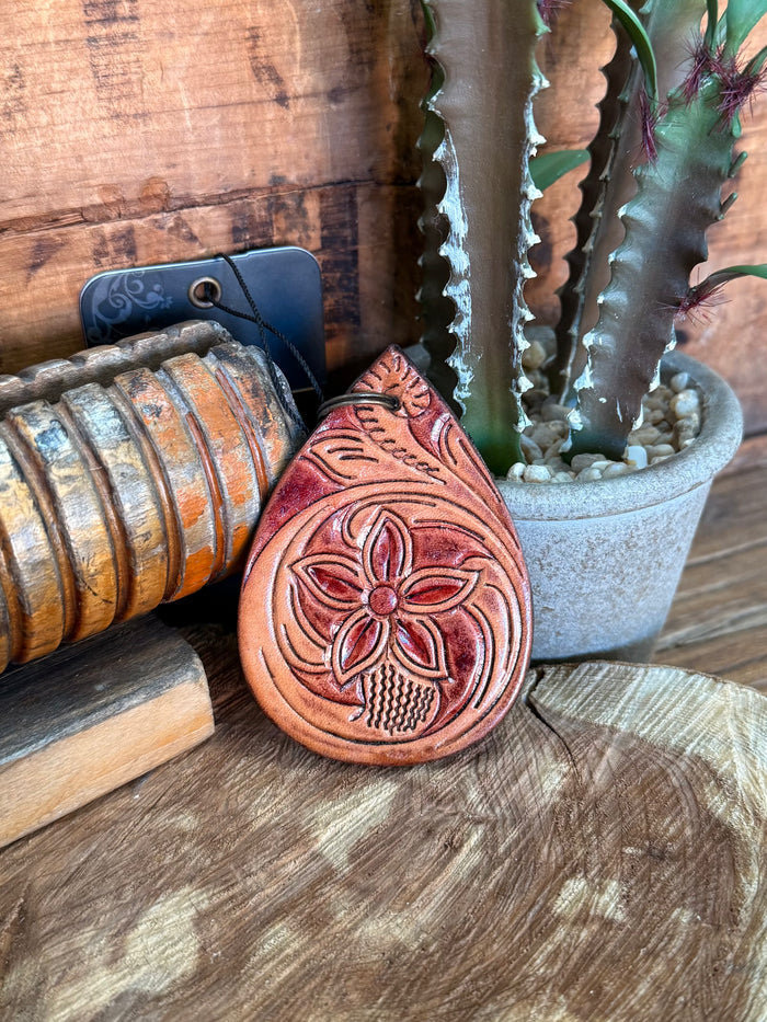Rounded teardrop cowhide key fob with carved floral tooling and metal key ring