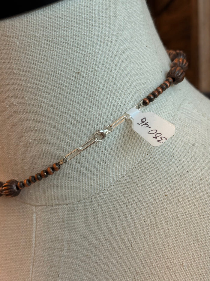 Copper necklace with lobster clasp and small engraved tag near clasp