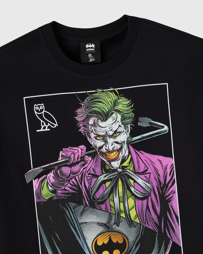 Black t-shirt featuring The Joker character in purple suit with green hair and a small owl symbol on the left side.