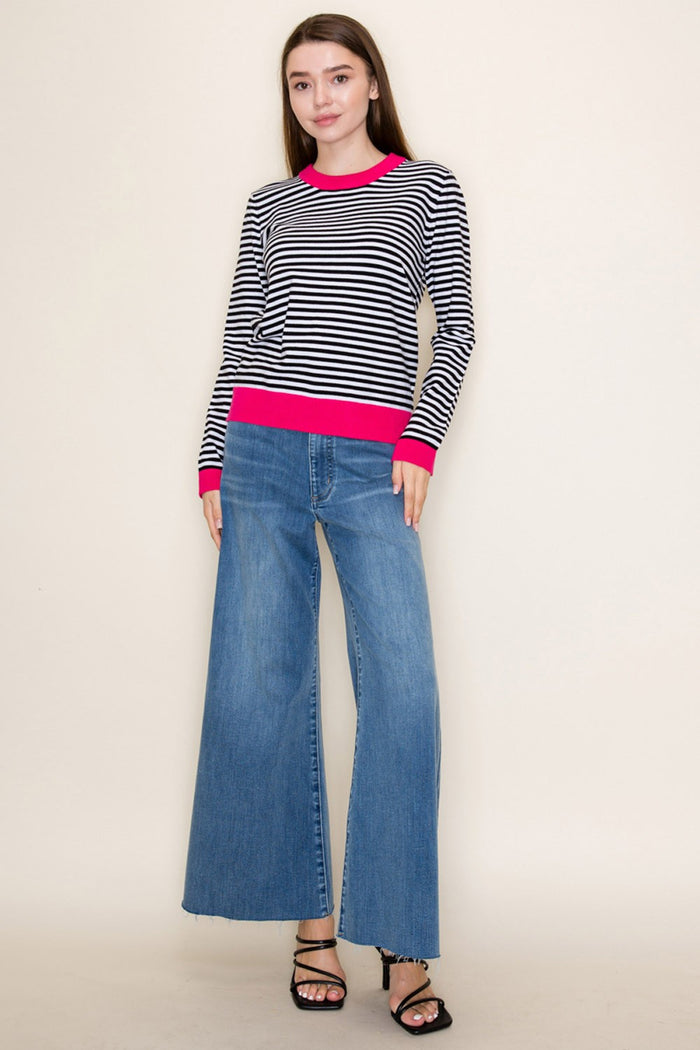 Black and white striped crew neck sweater with bright pink cuffs and hem
