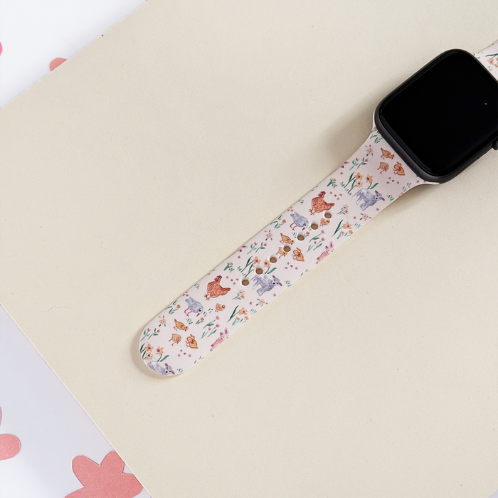 Beige silicone Apple Watch strap with pastel farm animals and pink floral accents by Coconut Lane.