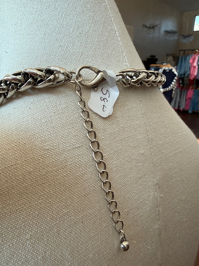 Silver-toned chain necklace with star pendant, small charm tag, and link extender
