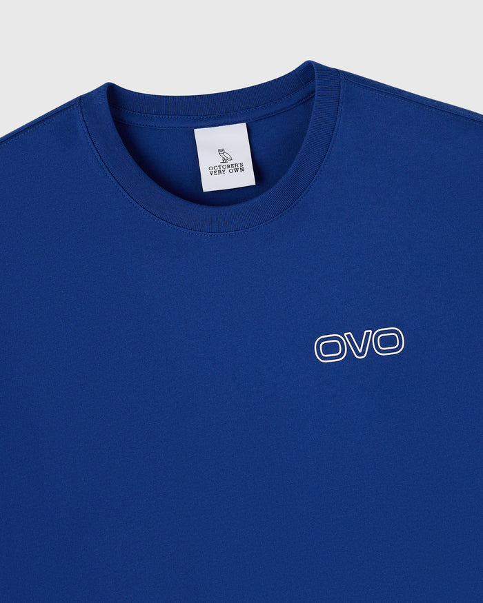Midnight blue crew neck t-shirt with white OVO logo on chest and brand label visible at neckline.