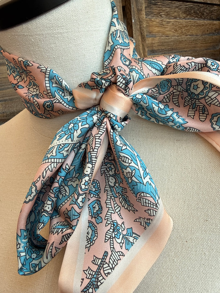 Pink and turquoise patterned twilly scarf knotted bow with long tails