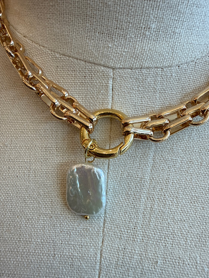 Gold-plated chunky chain necklace close-up with pearl-like drop charm