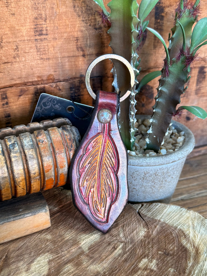 Teardrop cowhide key fob with carved leaf pattern, purple and tan accents, metal ring