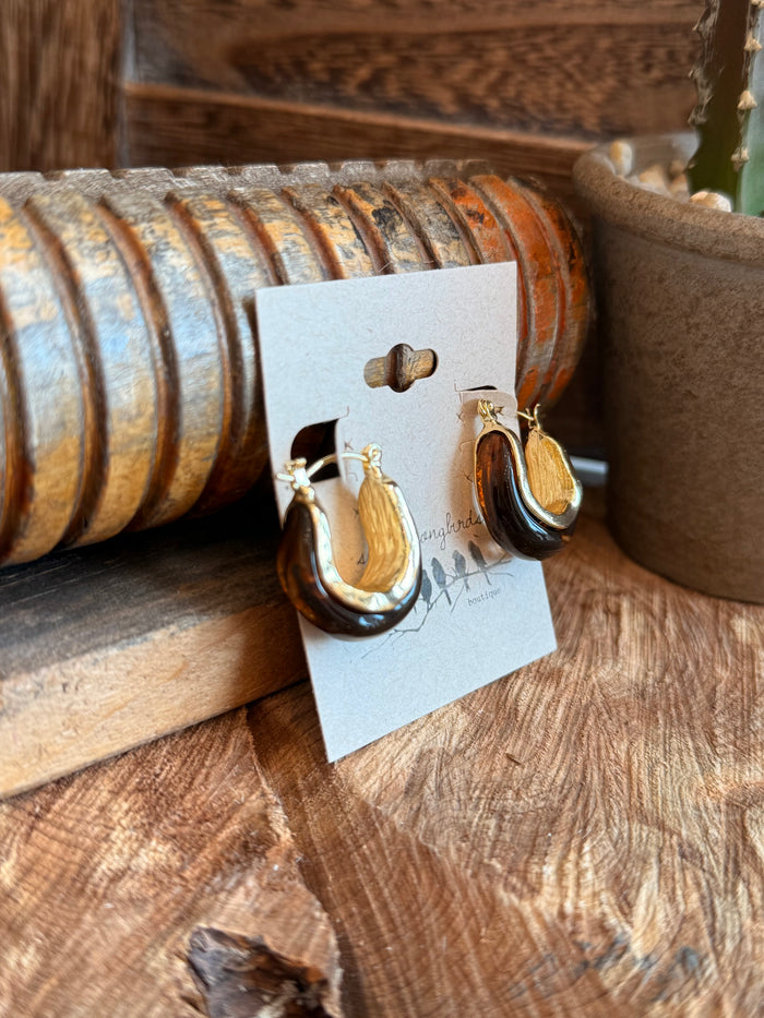Gold-tone teardrop hoop earrings viewed side, on card