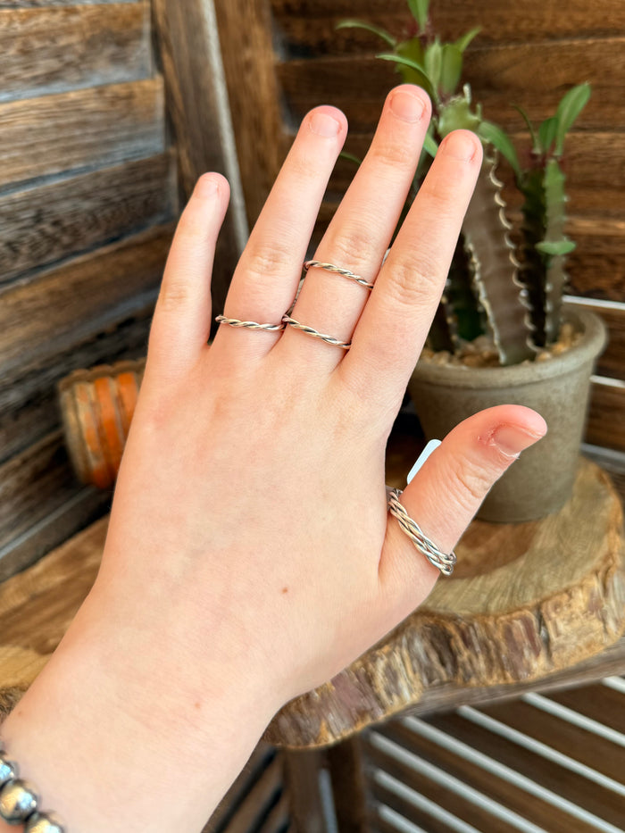 Sterling silver rope-wrapped ring with twisted band, worn on finger