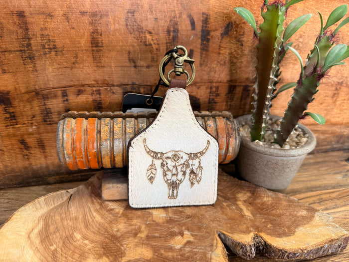 Cow skull hair-on key fob with white patch and gold-tone skull-and-feather design