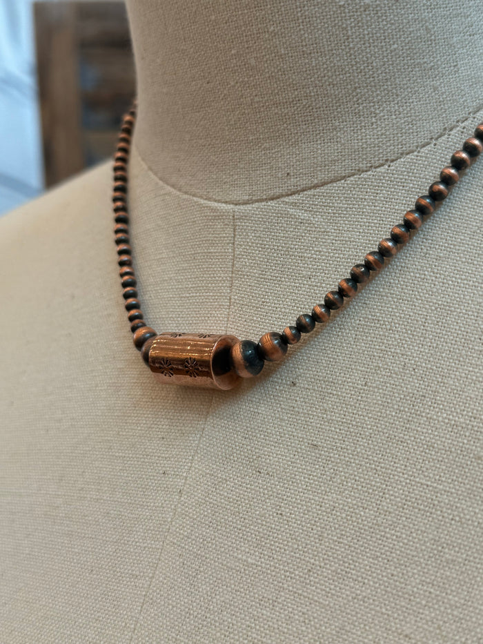 Copper barrel bead necklace detail with dark round beads and copper barrel centerpiece