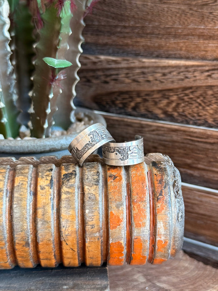 Sterling hoop earrings with engraved floral band detail and hinged hoop clasp.