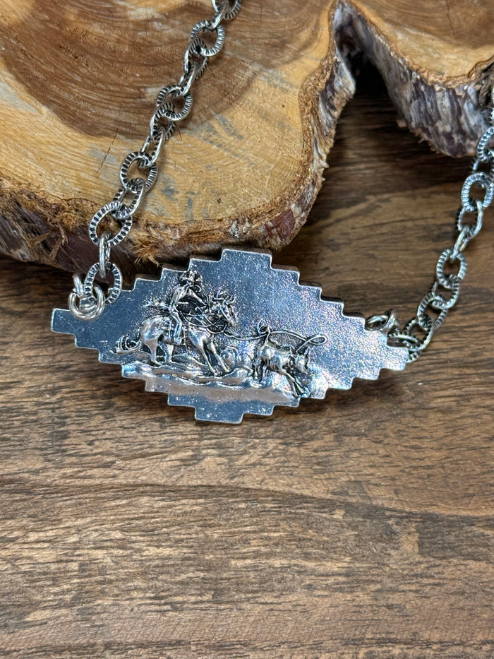 Silver-tone sunburst pendant necklace close-up with embossed floral design