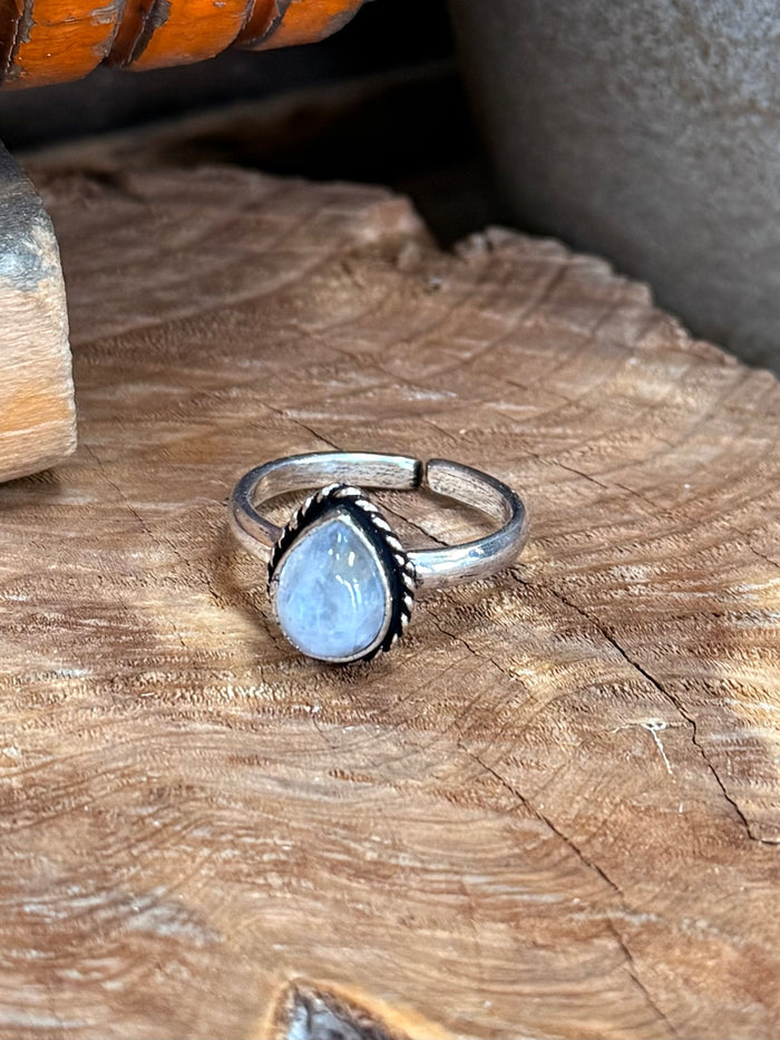 Oval light-blue stone atop silver adjustable ring with open sides