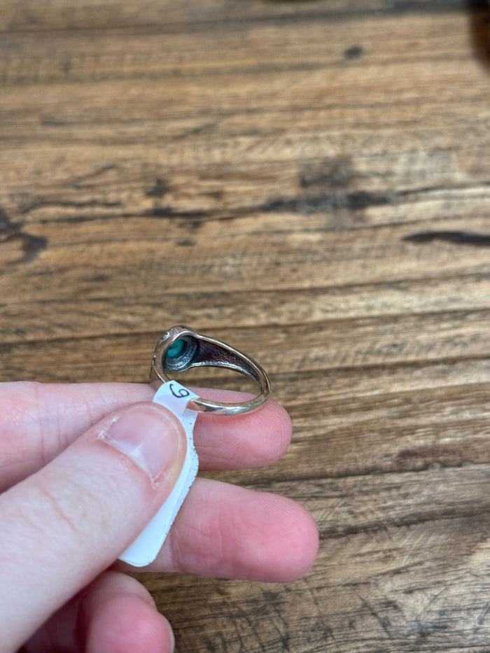Turquoise oval cabochon silver ring close-up on finger, size 6