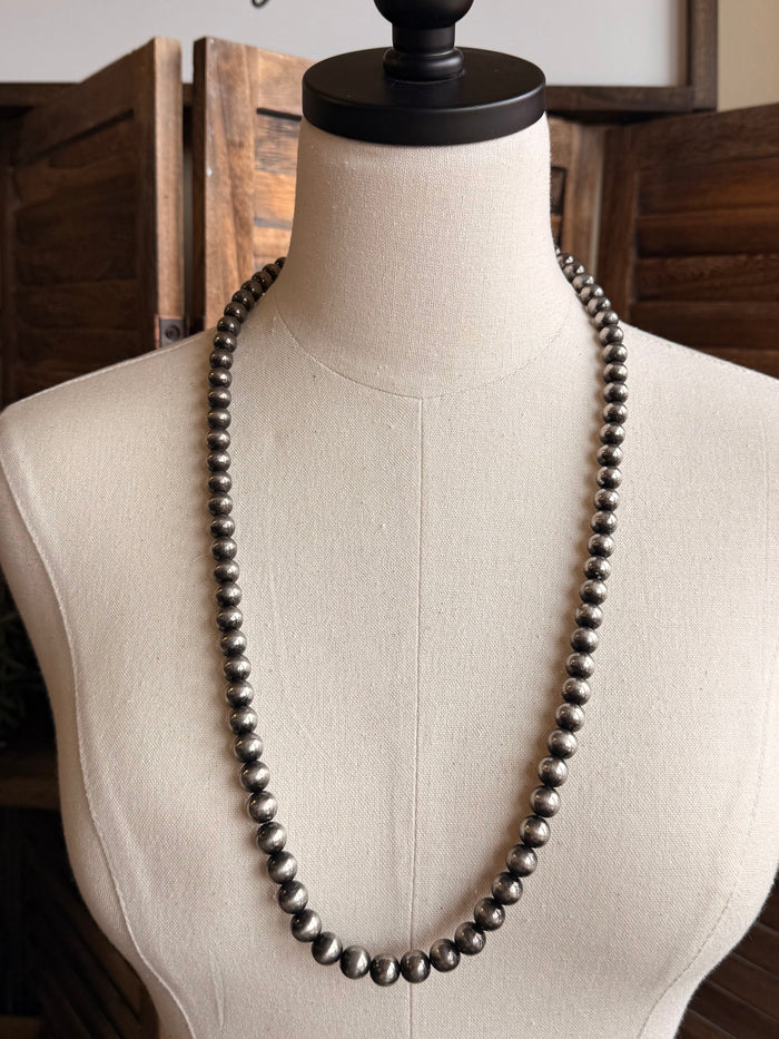 Dark silver metallic pearl bead necklace on mannequin, full length visible