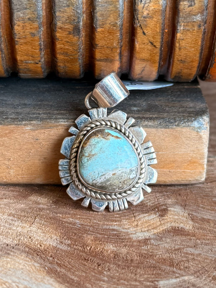 Sterling silver turquoise pendant with round turquoise cabochon and raised sunburst edge