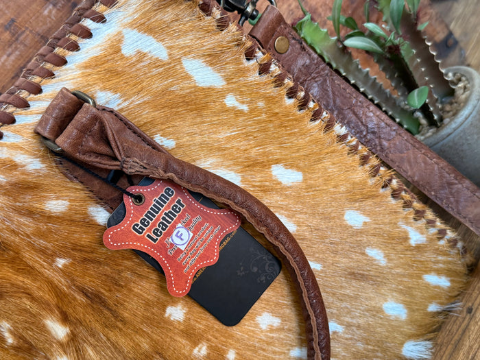 Deer-spotted cowhide briefcase tote with brown leather trim and hanging luggage tag