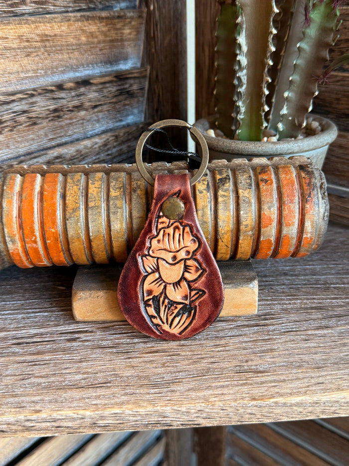 Tooled leather keychain with round metal ring and cowboy-style embossed face, brown