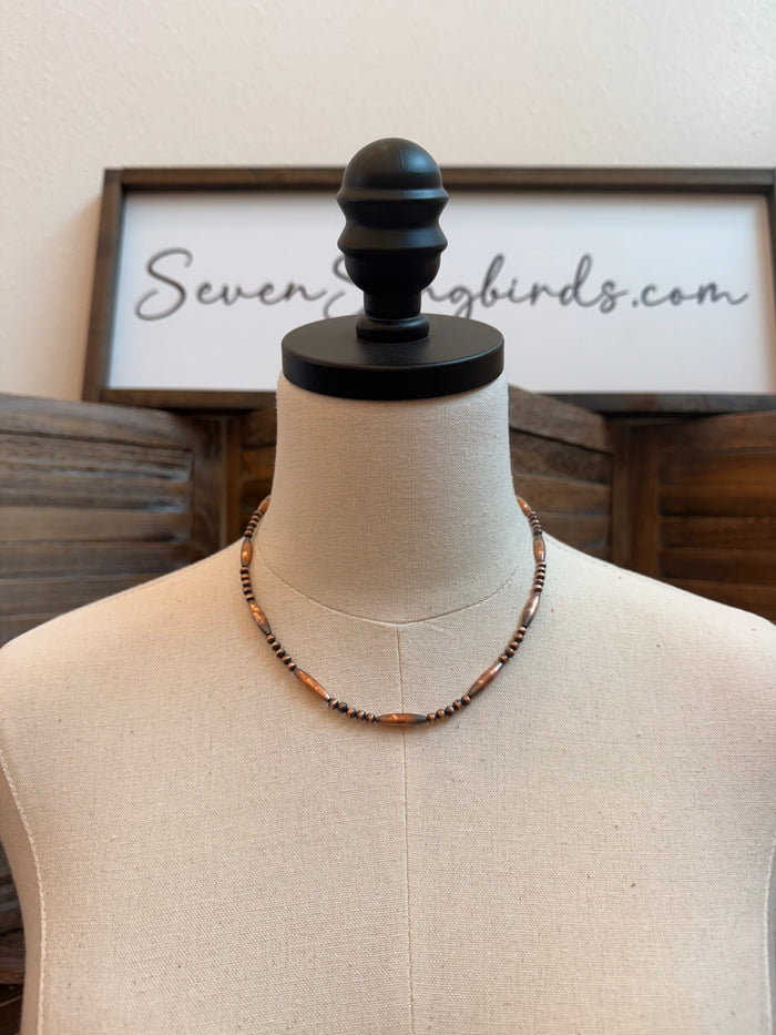 18-inch copper torpedo bead necklace on mannequin, dark seed-bead accents