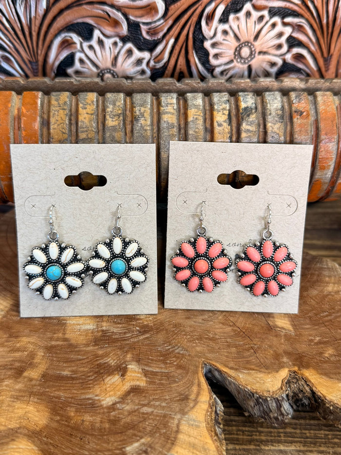 Flower fishhook earrings set with blue-centered white and coral-pink flower drops