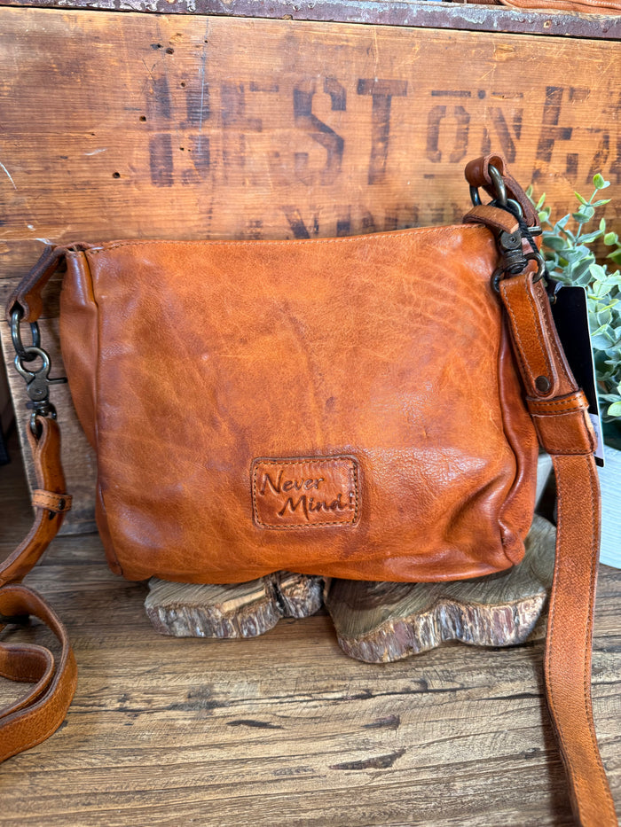 Studded cognac leather flap crossbody purse back with 'Never Mind' logo patch