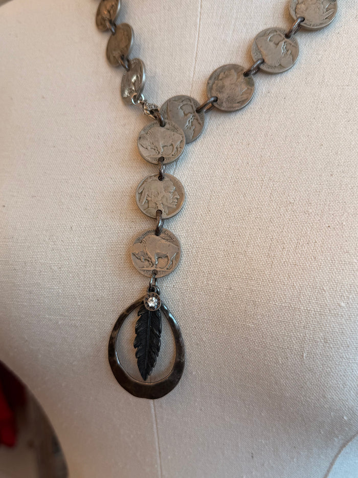 Feather pendant necklace close-up of coin chain with teardrop feather drop