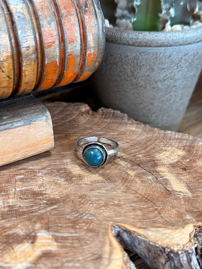 Silver-plated adjustable ring with oval blue apatite stone in bezel setting