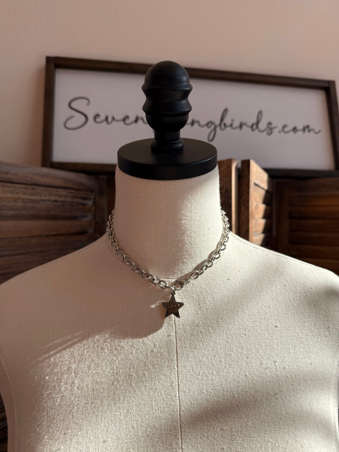 Silver star pendant necklace with curb chain on a mannequin bust