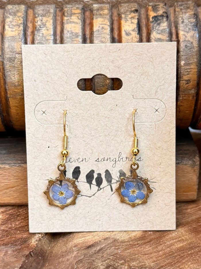 Gold-tone fishhook earrings with blue flower drop charms on display card
