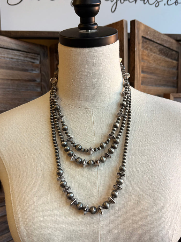 Graduated silver pearl rondelle necklace, V-shaped on mannequin neck