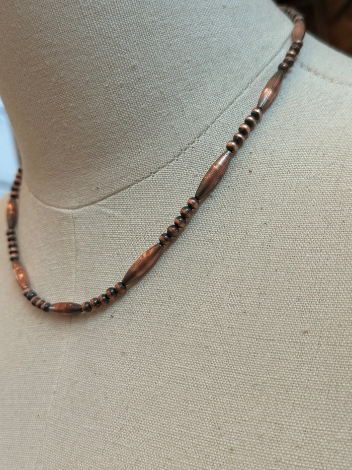 Close-up of copper torpedo bead necklace with dark accent beads