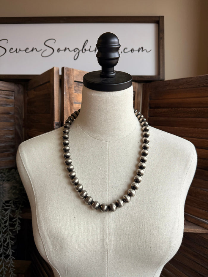 Graduated silver pearl necklace with dark metal bead accents