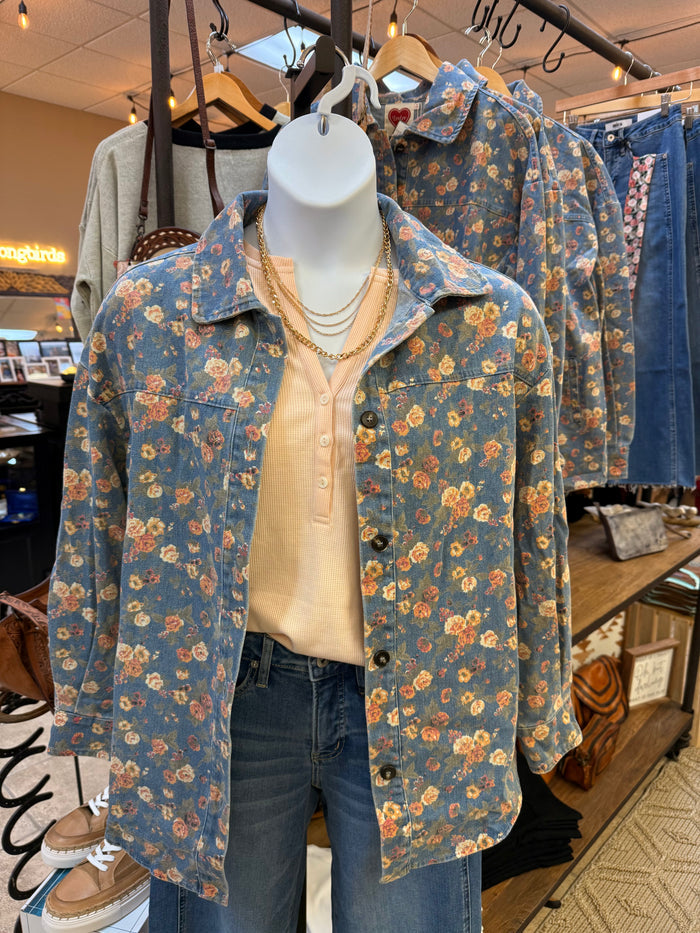 Floral denim button-front jacket on mannequin, collared, long sleeves, chest buttons