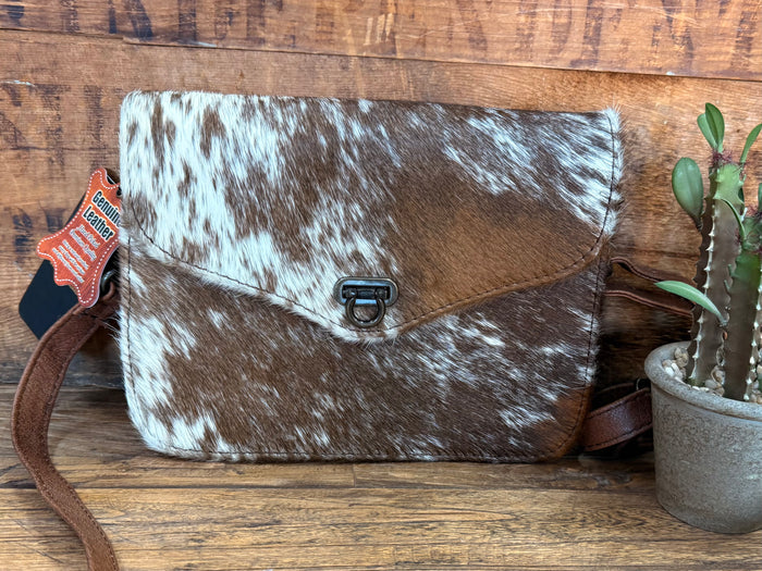 Mini flap crossbody purse with cowhide hair-on texture, dark-and-white pattern, metal buckle
