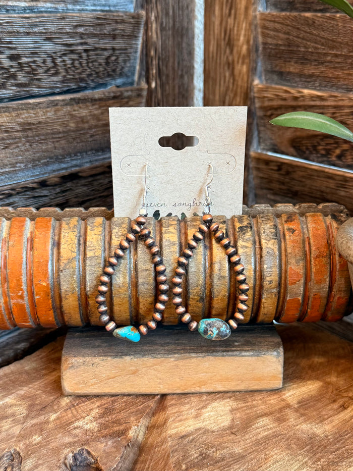 Copper hoop earrings with turquoise teardrop accents and twisted bead detail