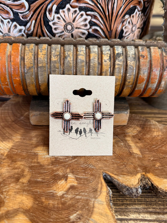 Zia symbol stud earrings with white stones and cactus detailing on display card