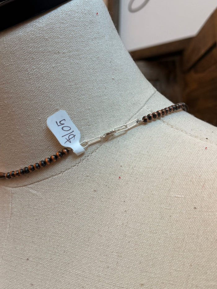 Copper torpedo bead necklace clasp and chain end on mannequin bust