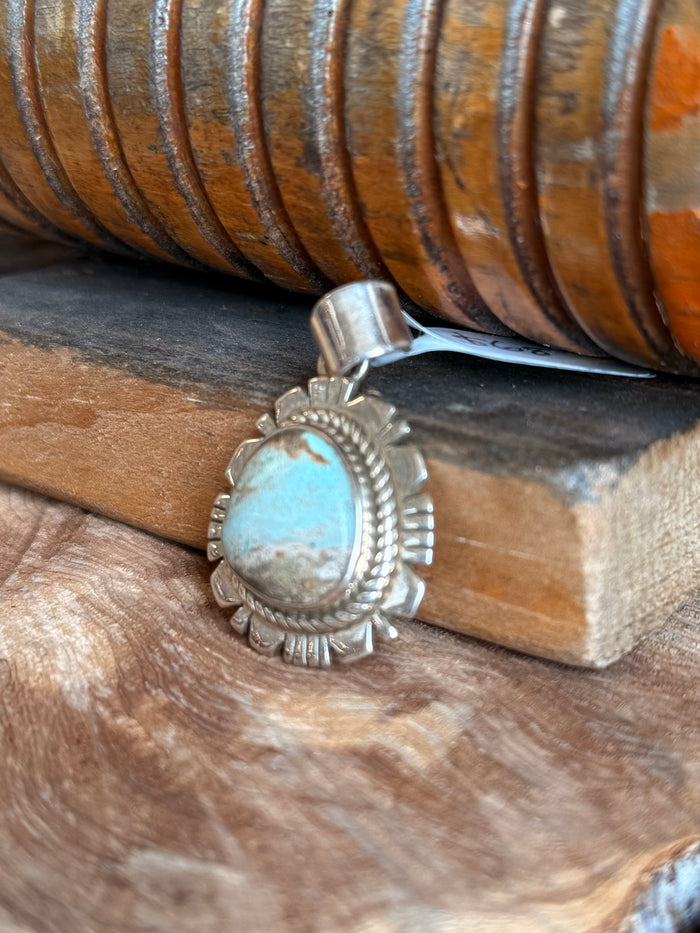 Sterling silver turquoise pendant showing bail and sunburst setting around oval cabochon