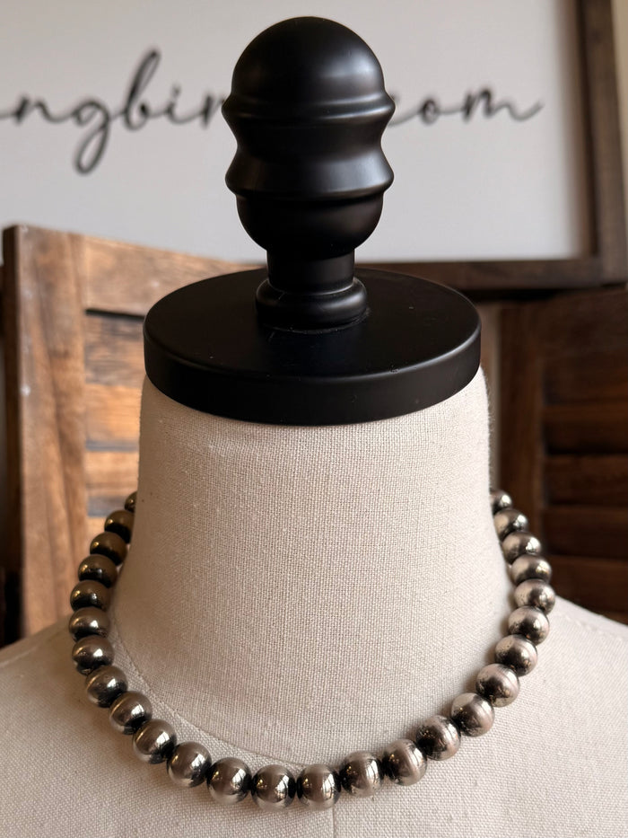 Graduated silver pearl necklace on mannequin, bead strand with chain and clasp