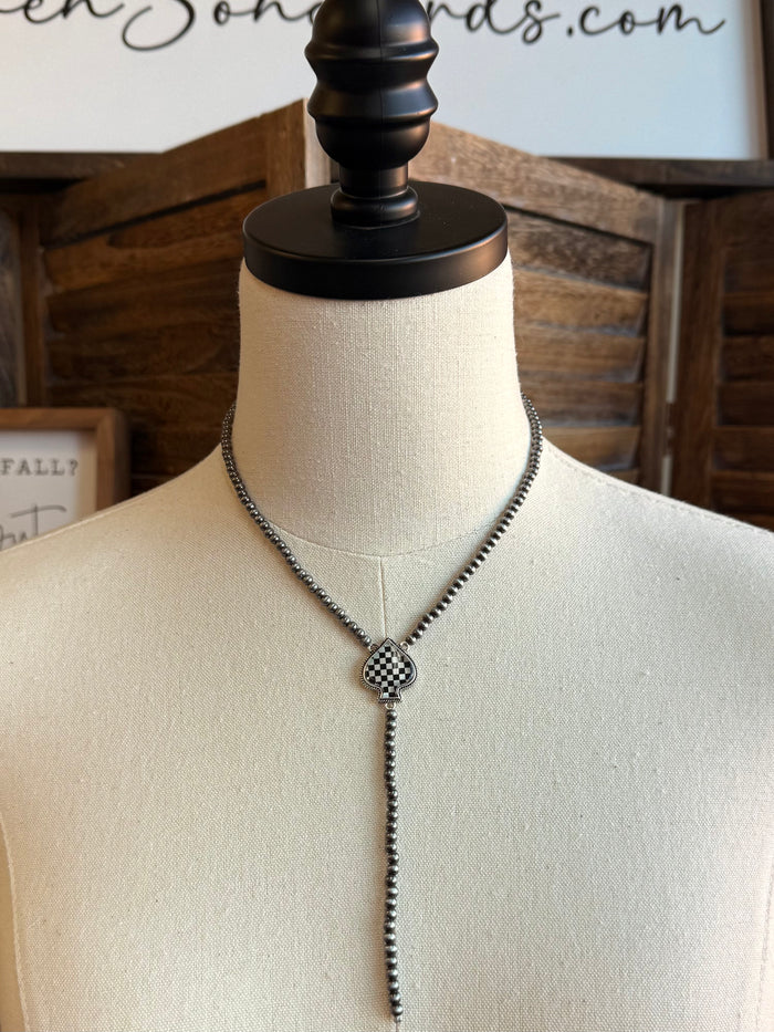 Lariat necklace with checkered spade pendant centered on dark beaded chain