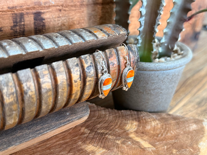 Handmade fishhook earrings with orange opal oval and blue spiny inlay, side view