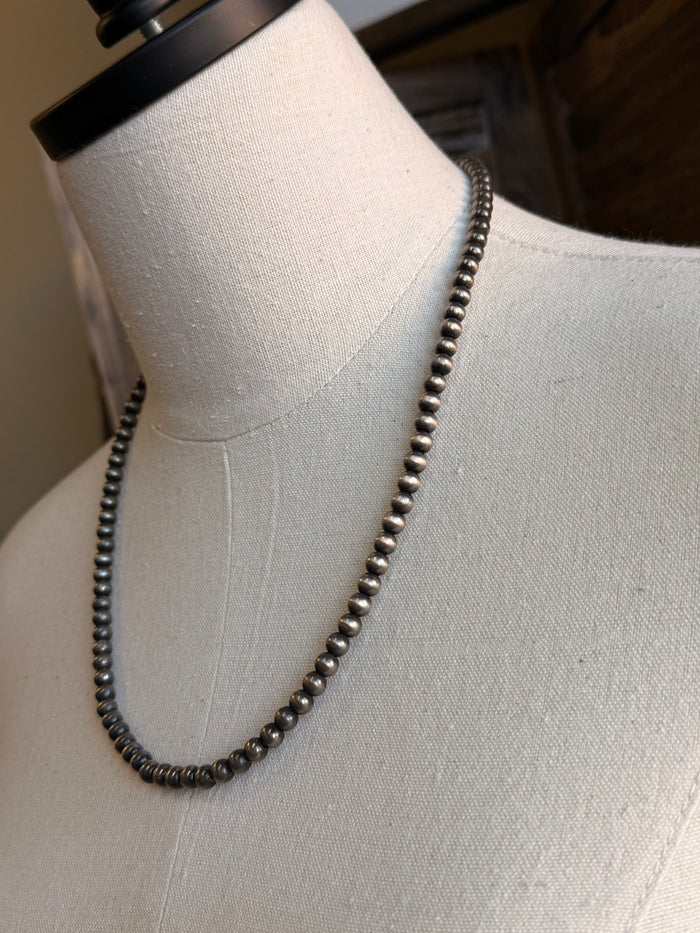 Silver-tone 21-inch beaded necklace with 6mm round beads, angled close-up